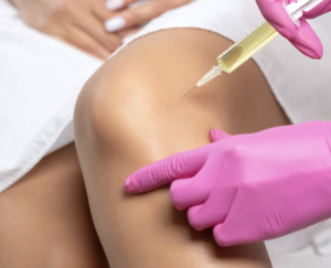 Stem cell injection into knee joint for orthopedic pain relief, performed by medical professional wearing pink gloves.