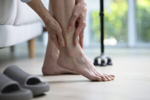 Mature woman holding ankle in pain.